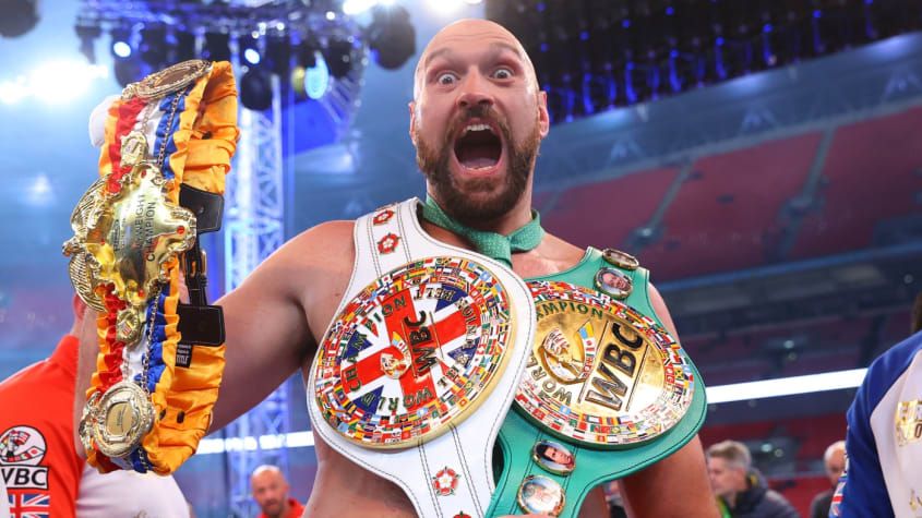 Tyson Fury holding up his medals