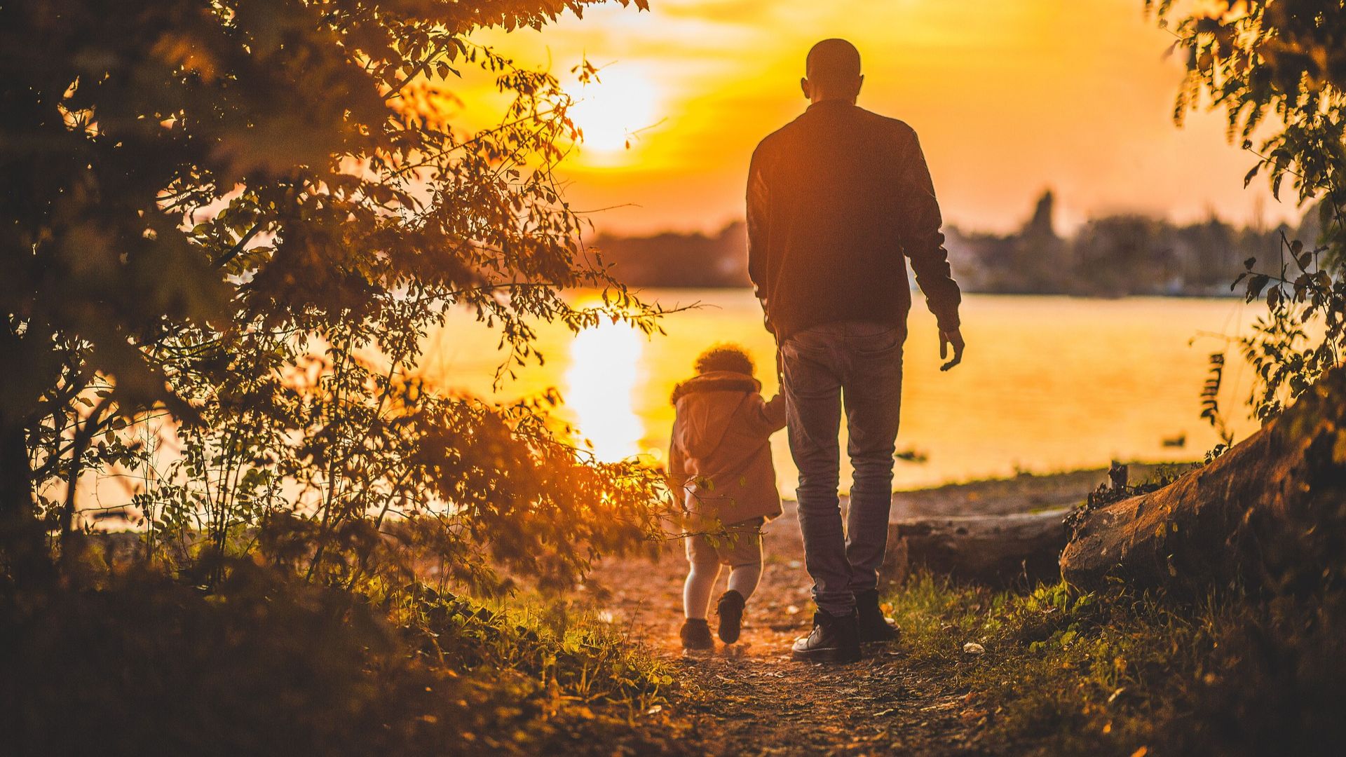 Grandparent and grandchild walking at sunset