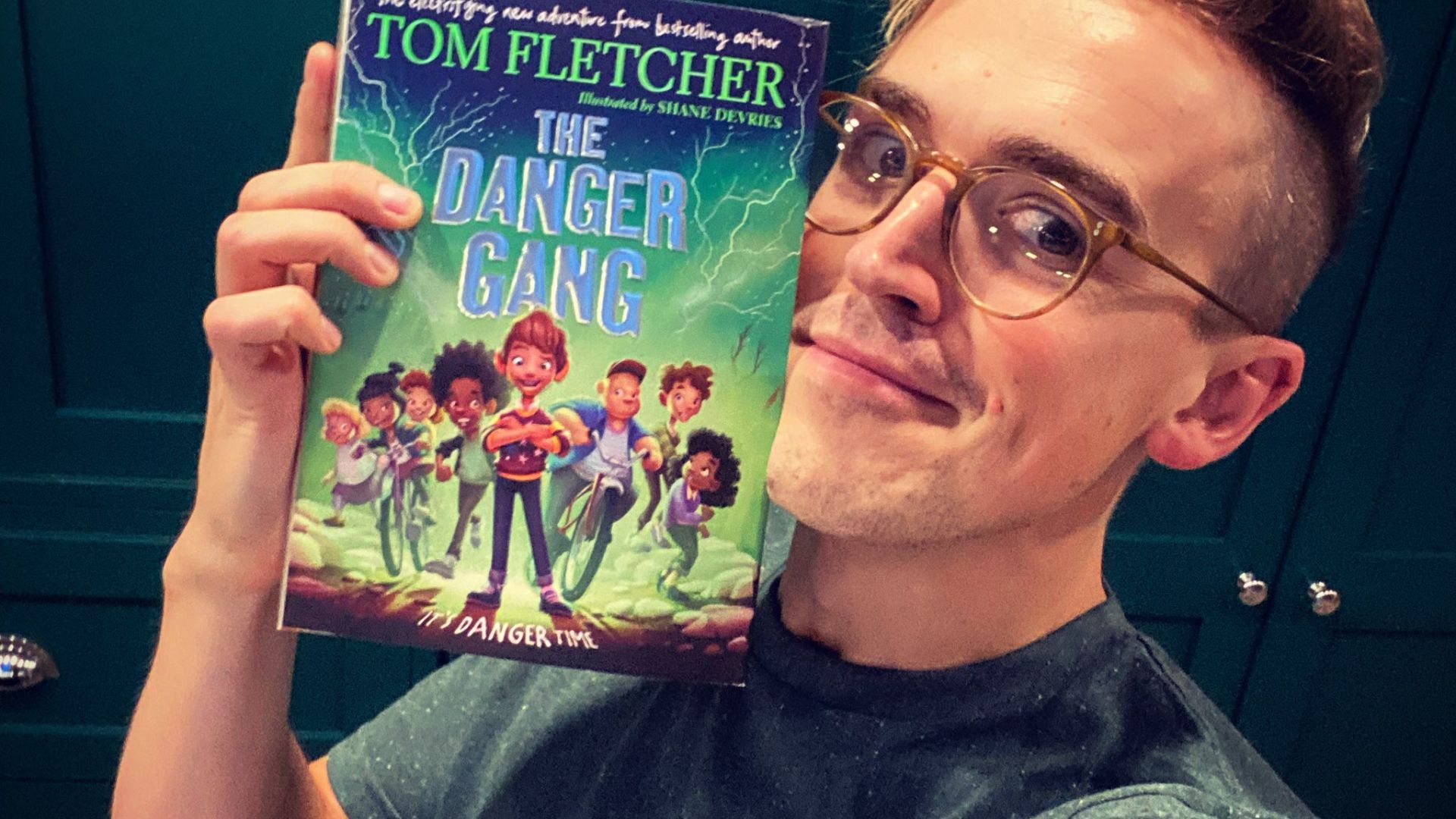 Tom Fletcher holding his book The Danger Gang